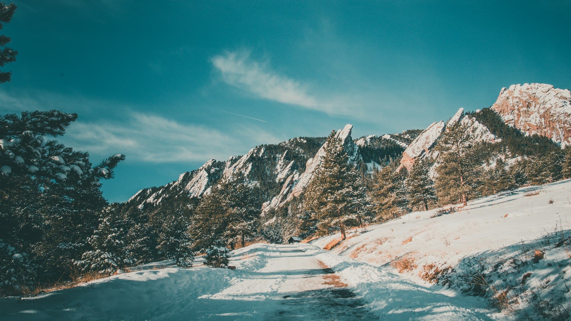 A snow-covered path leading toward the mountains outside Boulder